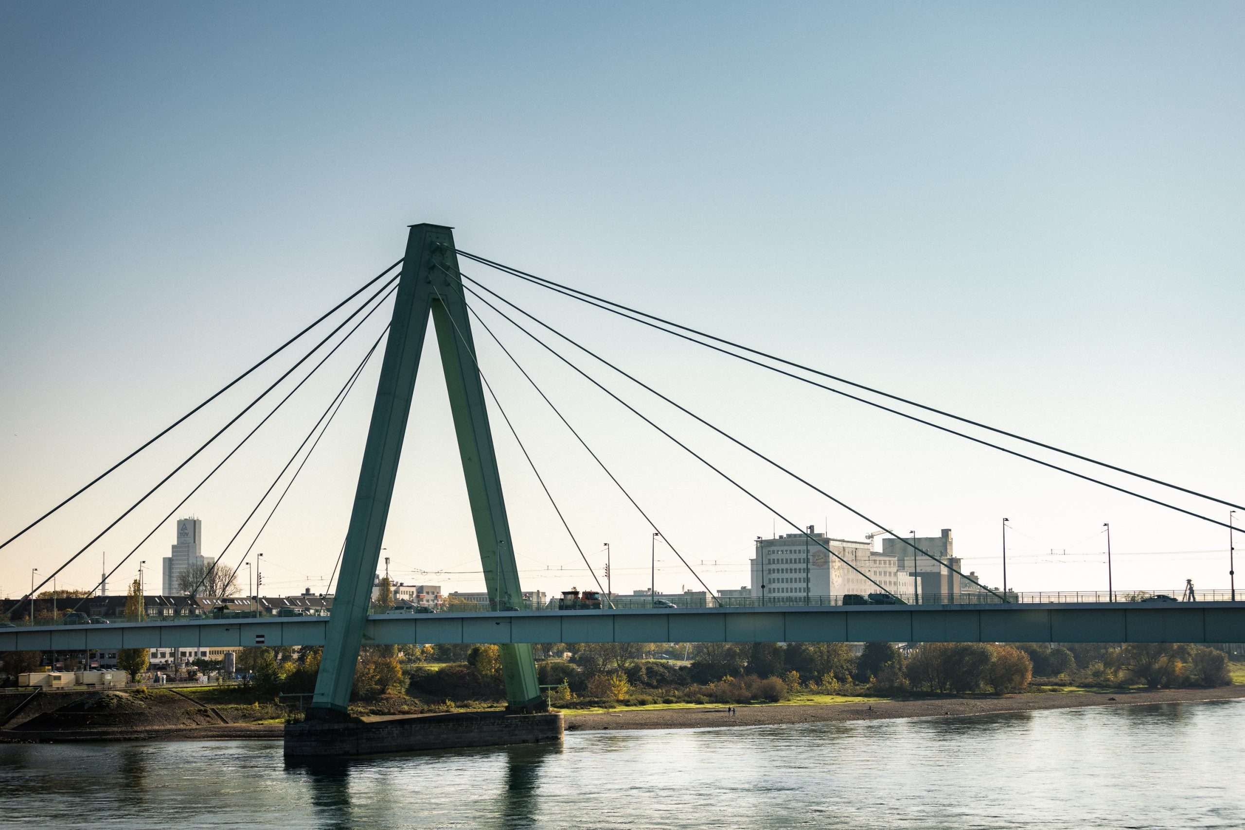Die Severinsbrücke in Köln. Eine große, metallene Brücke mit Bögen und Streben, die den Rhein überspannt.